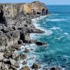 View across limestone cliffs with an aquamarine sea and white waves breaking over the rocks. Location pictures is St Govan&#039;s Head, Pembrokeshire