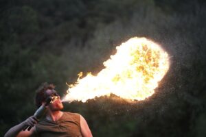 A fire eater against a dark background.